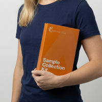 Person holding an orange 'Sample Collection Kit' from Optimal You against a plain background