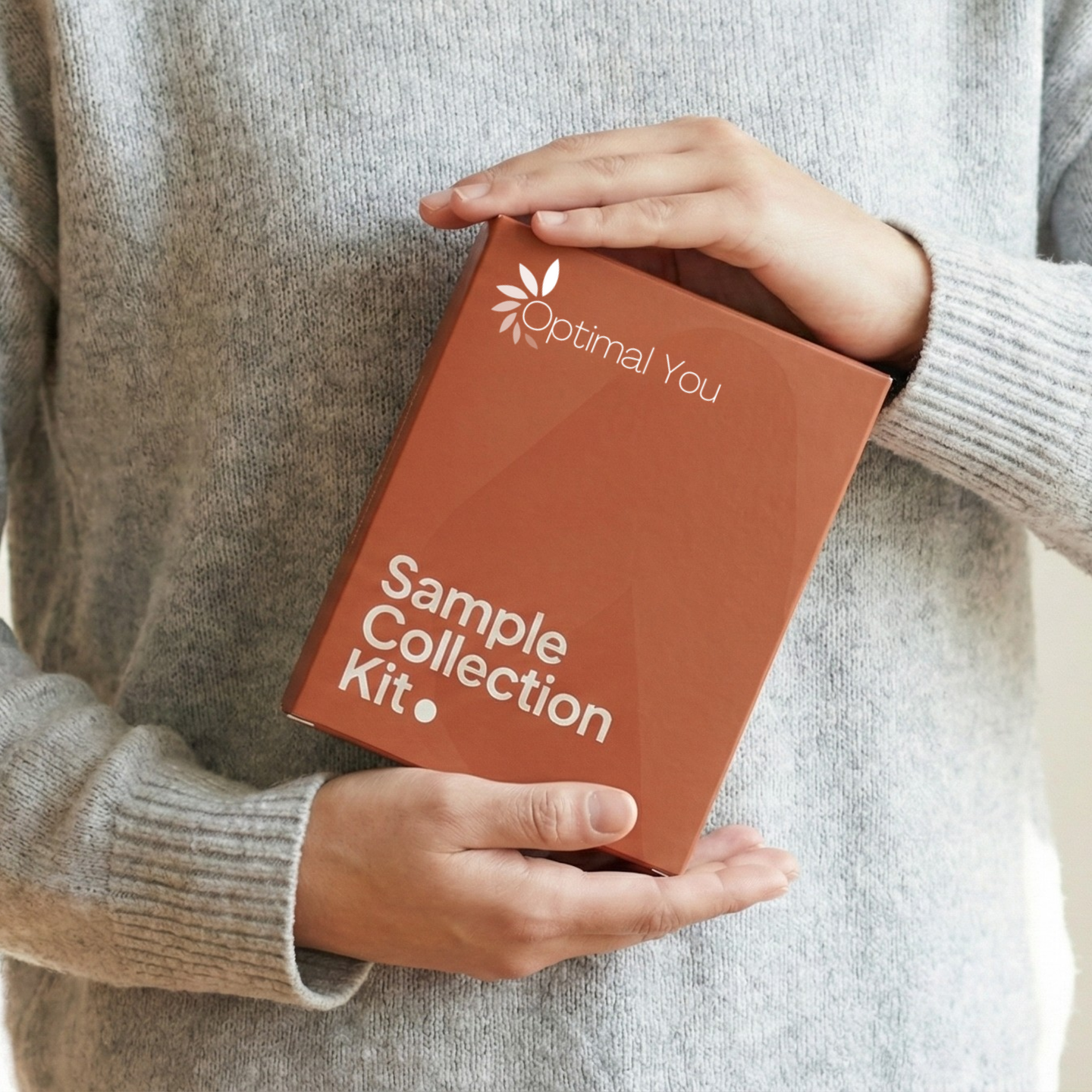 Person holding a 'Sample Collection Kit' by Optimal You