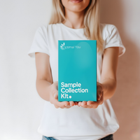 Person holding a teal 'Optimal You' sample collection kit against a neutral background