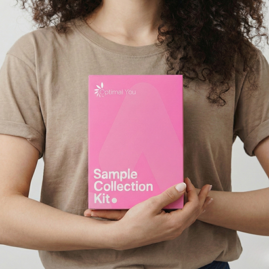 Person holding a pink 'Optimal You' sample collection kit against a neutral background